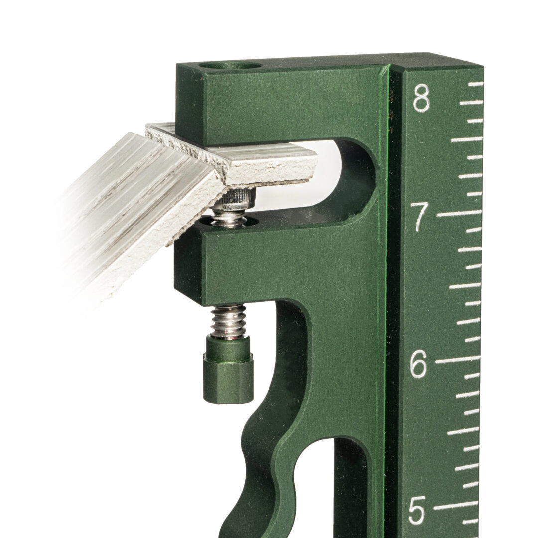 A green measuring tool with a metal handle.